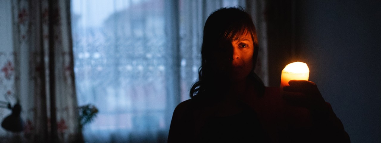 Woman with candle in power blackout
