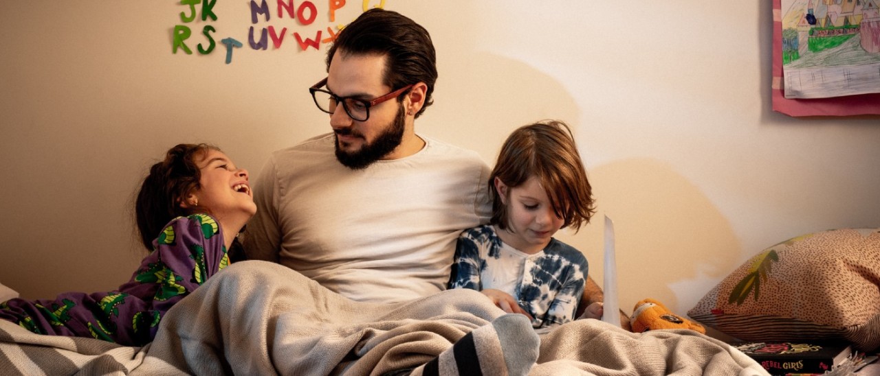 Home-Lifestyle-Family-Evening-RACV-1400x600 man and children sitting on bed at night