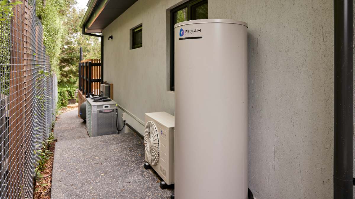 A heat pump hot water system installed at the side of a house