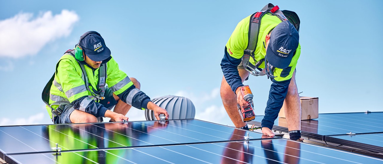 RACV-Solar-1132-1400x600.jpg Two tradespeople installing solar panels