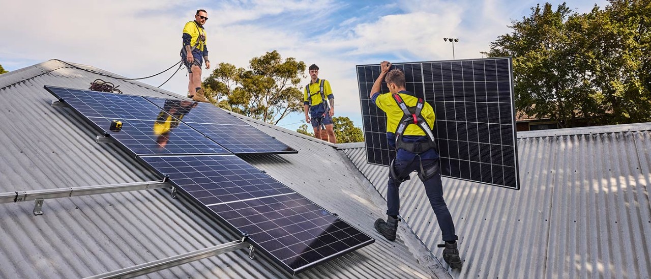 Technicians installing solar panels on a colourbond roof