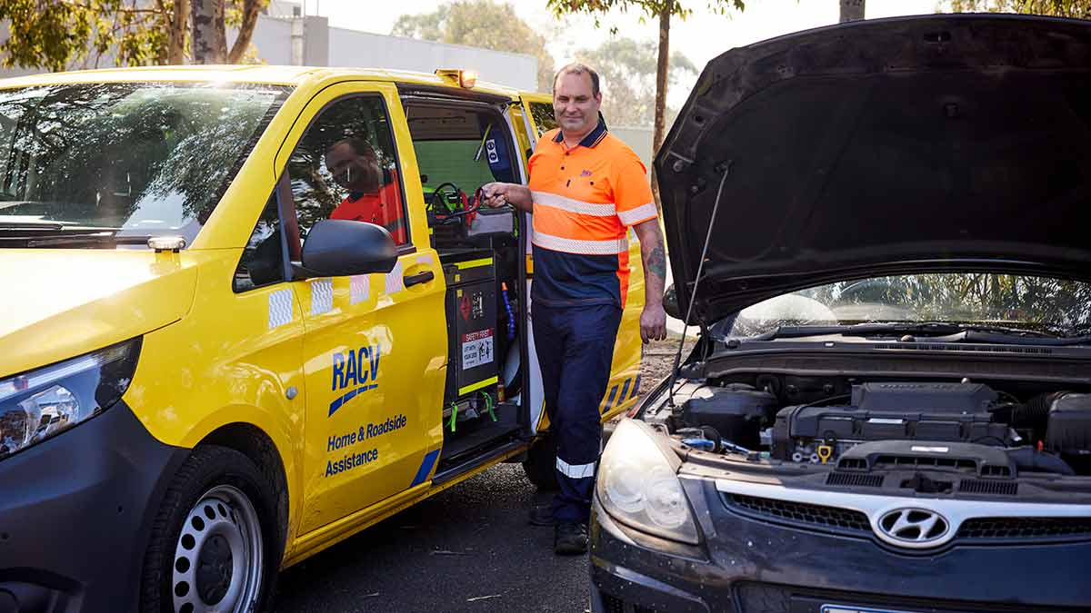 RACV technician attending to flat battery in dark Hyundai car