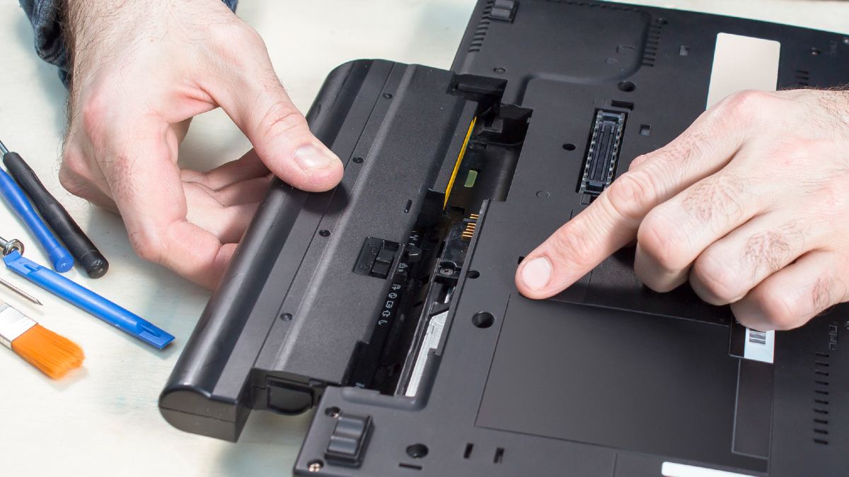 lithium ion battery being removed from a laptop