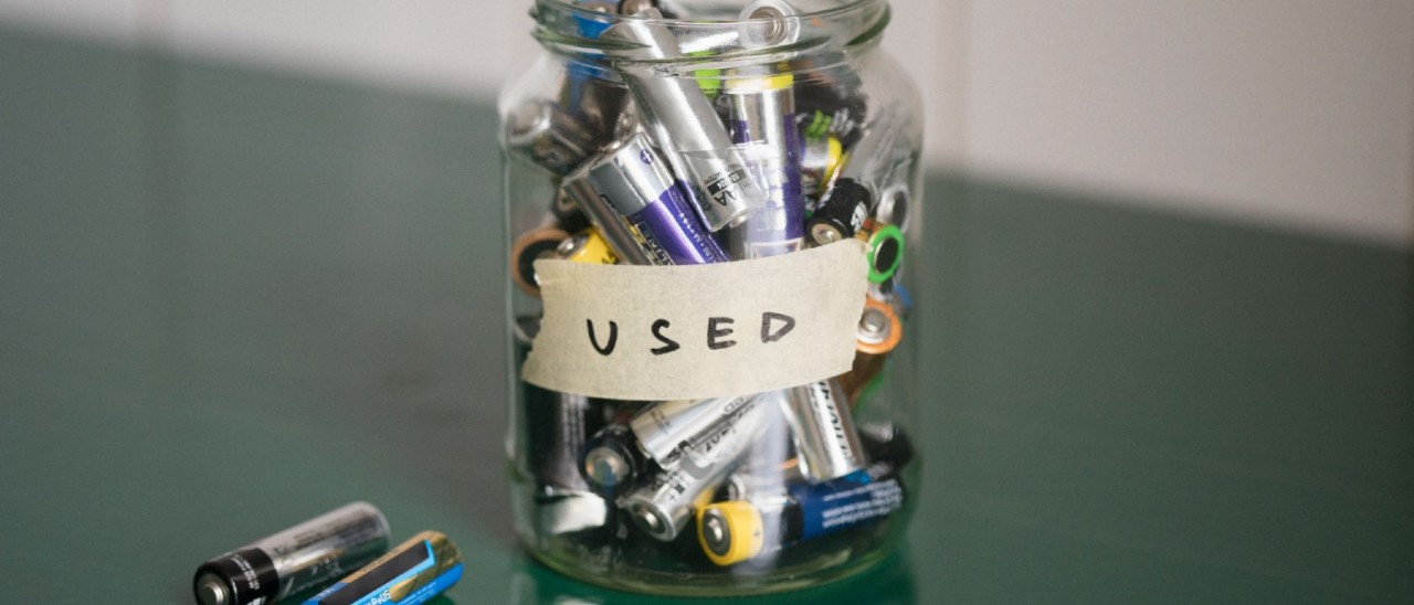 glass jar full of batteries; label reads USED