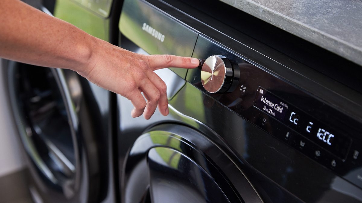 man putting a clothes dryer cycle on