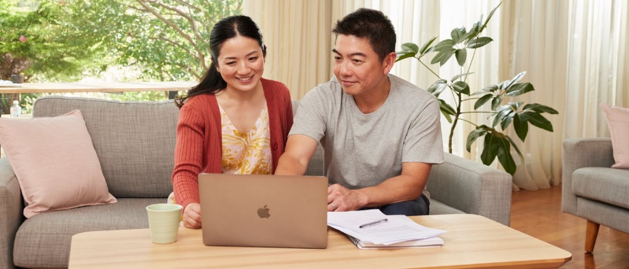 A couple happily planning in front of a laptop A couple happily planning in front of a laptop