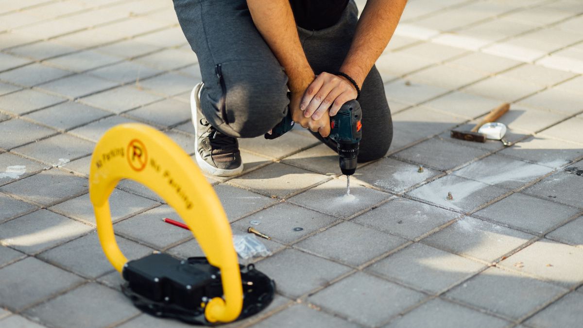 man installing bollards in driveway