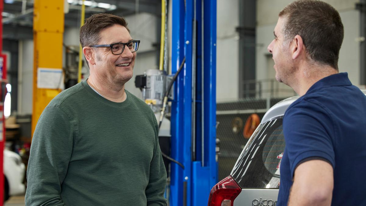 Person talking to a mechanic in auto repair centre