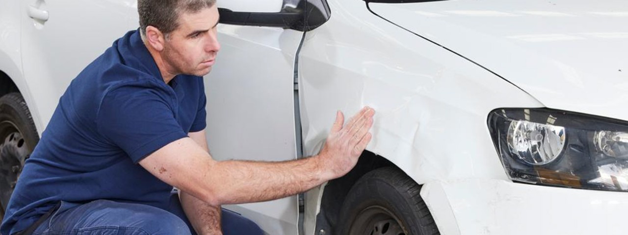 Mechanic inspecting damage on a car