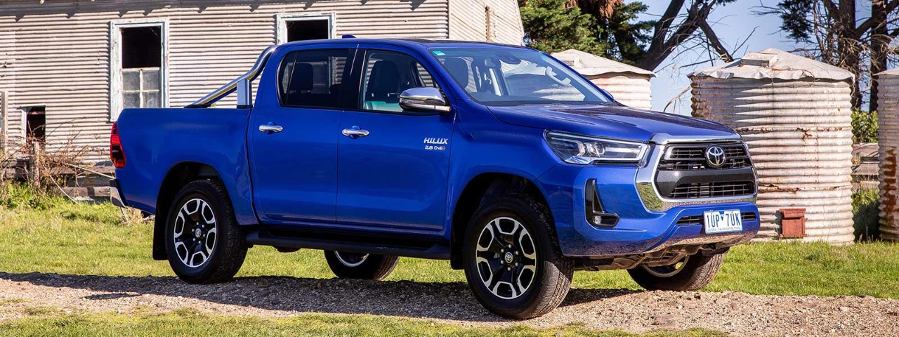 toyota hilux blue parked in front of farmyard