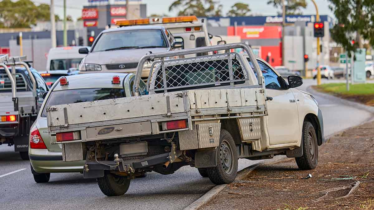Ute going over kerb to get to right-hand turning lane at congested traffic lights.,