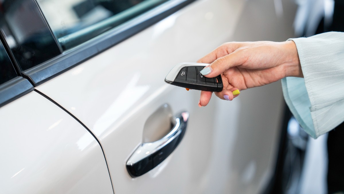 woman unlocking car with electronic key fob