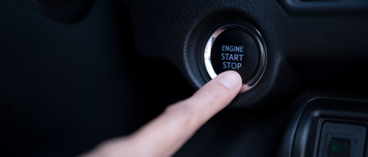 Car Push Start Button_Getty_1400x600 person pushing start button in car
