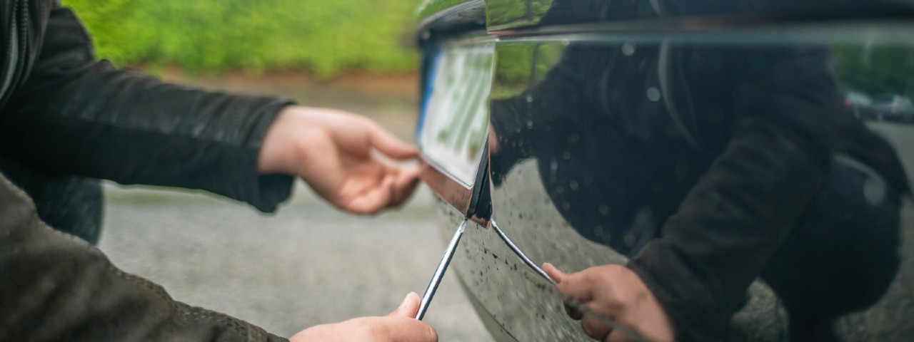thief removing car number plate