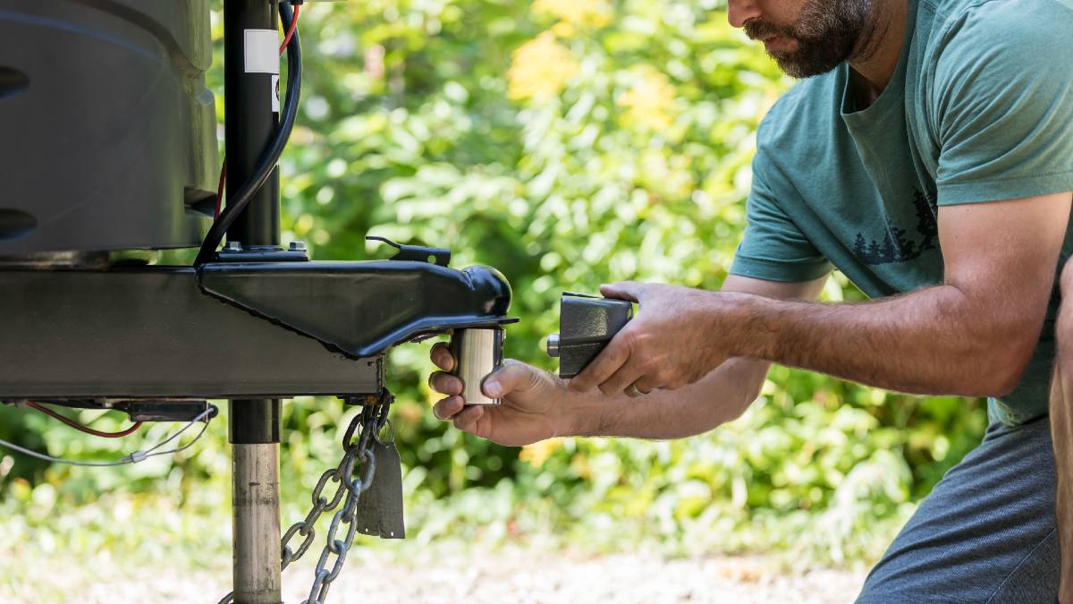 man attaching a towing padlock to his caravan