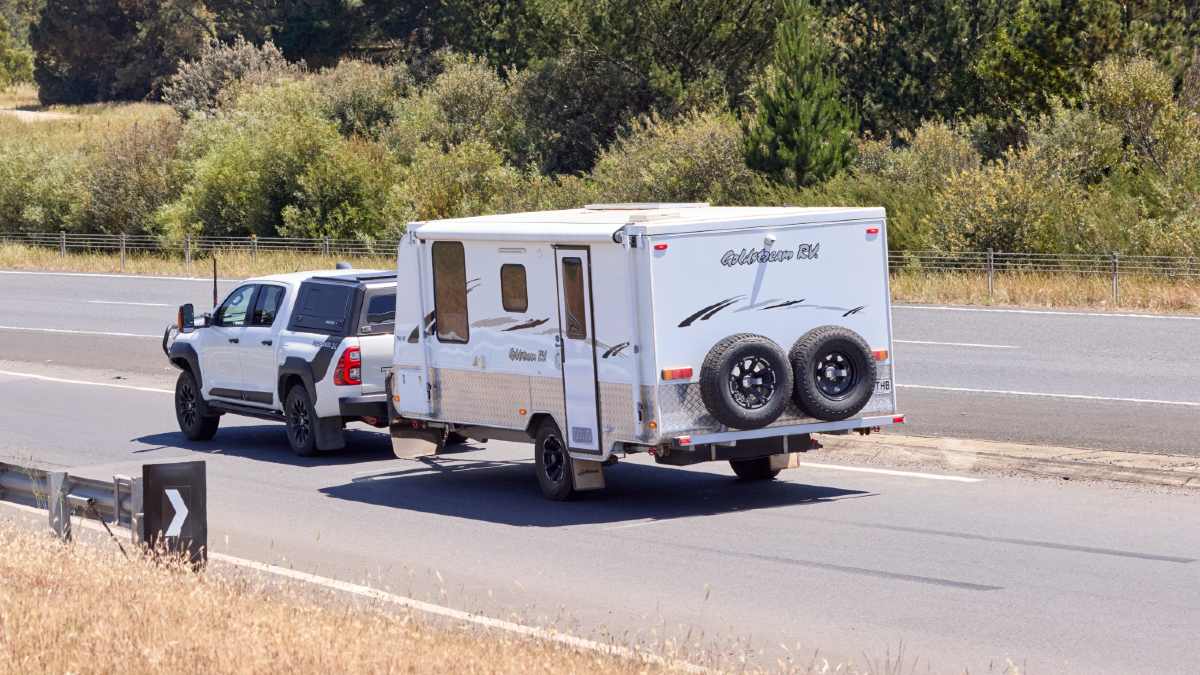 white caravan being towed on road