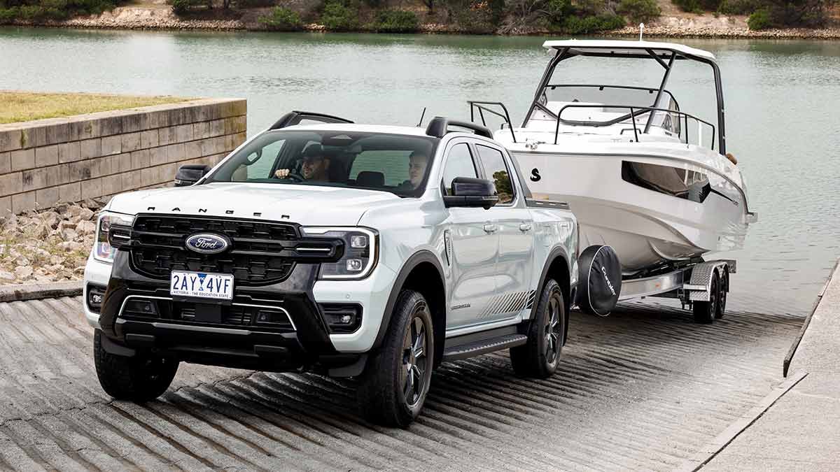 White Ford Ranger PHEV Stormtrak ute on boat ramp with large white fishing boat