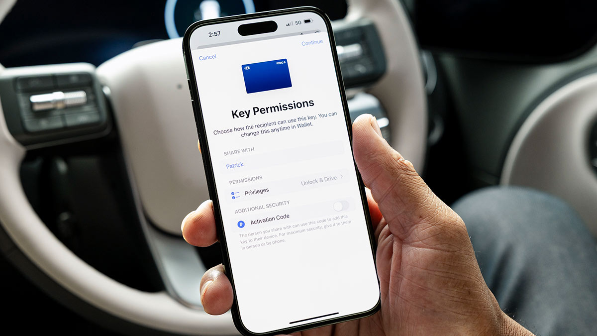 Driver's hand with smartphone showing digital key menu in cabin of Hyundai Tucson SUV