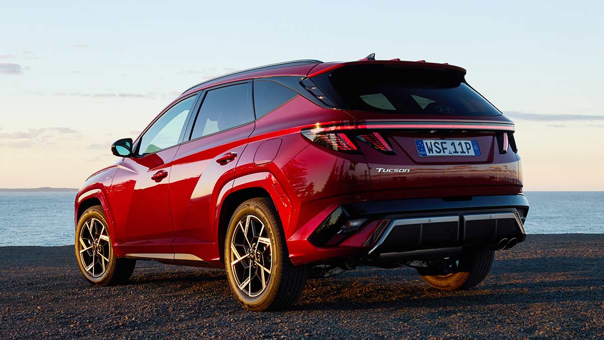 Rear shot of red Hyundai Tucson Premium N Line Hybrid SUV at beachside carpark