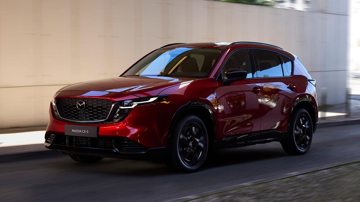 Red Mazda CX-5 medium SUV driving through underpass.
