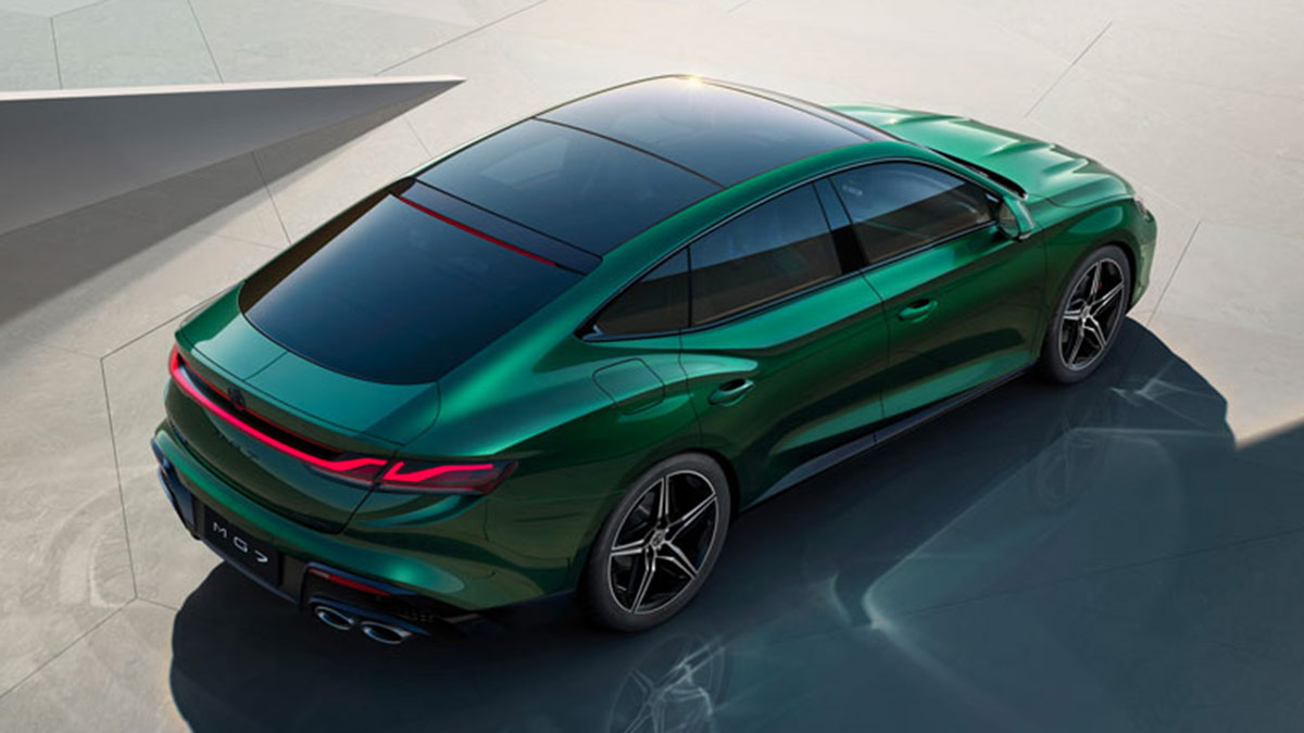 Overhead view of green MG7 sports sedan on bright, shiny, light-coloured forecourt.