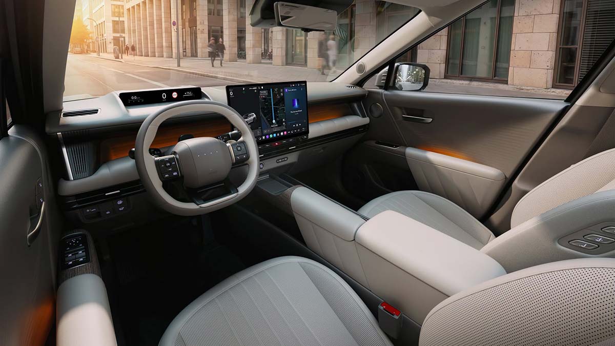 Driver’s area of 2027 Hyundai Tucson with cream trim, high-mounted driver’s display, oval-shaped steering wheel and large touchscreen.