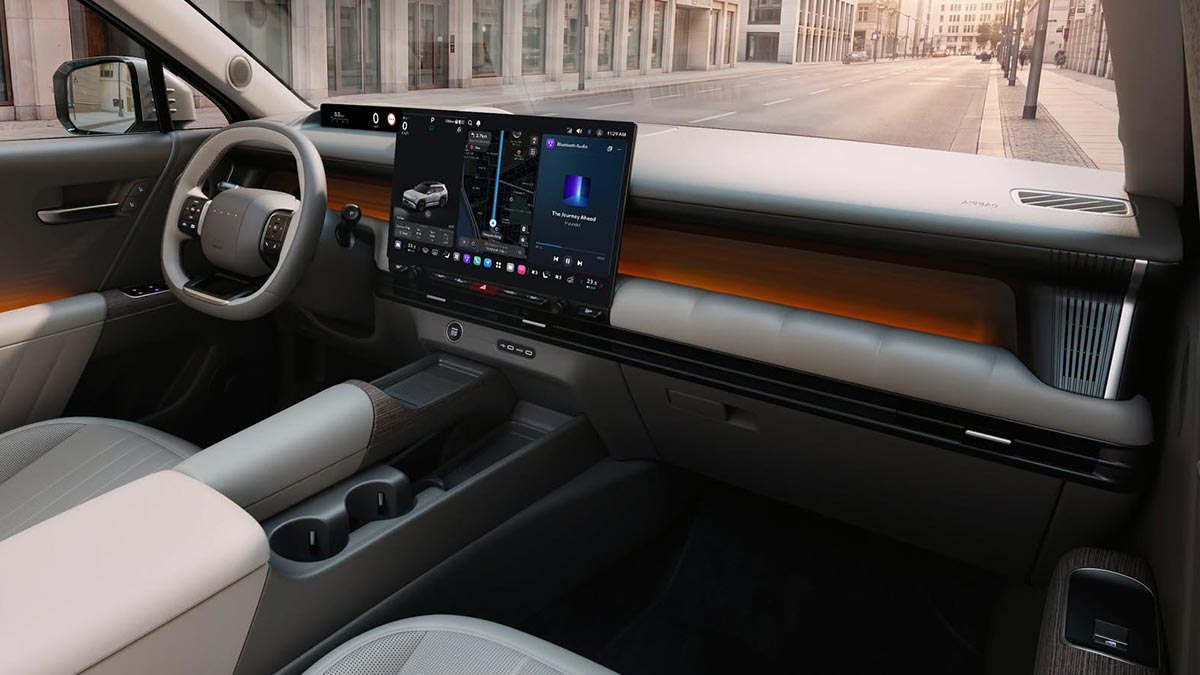 View inside Hyundai Tucson parked on empty city street showing cockpit area with large central screen and 2-tone cream/black dash trim with orange ambient lighting.