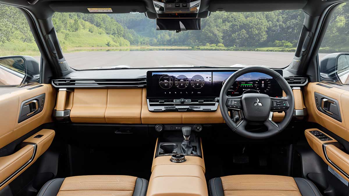 Dashboard of 2026 Mitsubishi Pajero SUV with tan-coloured trim and dual 14.3-inch digital screens.