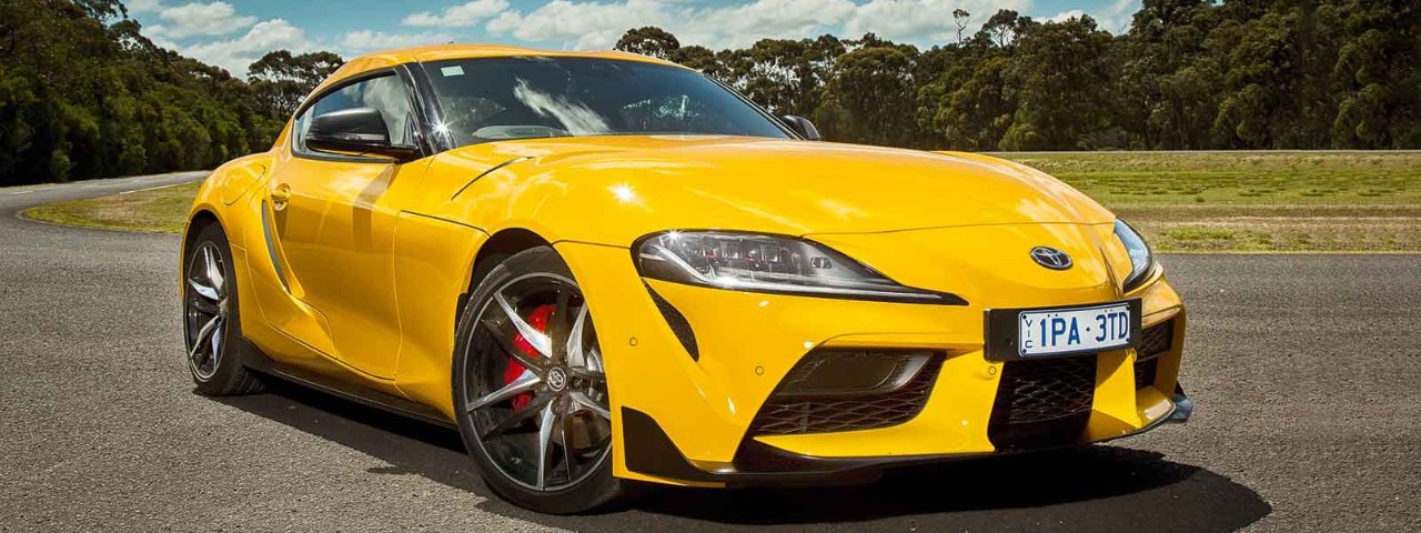 yellow toyota supra parked on road