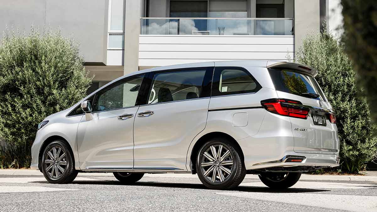 Light grey metallic 2021 Honda Odyssey Vi L7 people-mover parked outside modern two-storey suburban home.