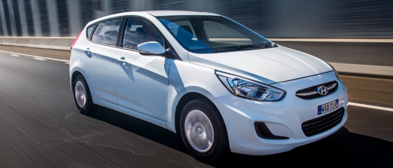 A white Hyundai Accent 2016 driving on a road