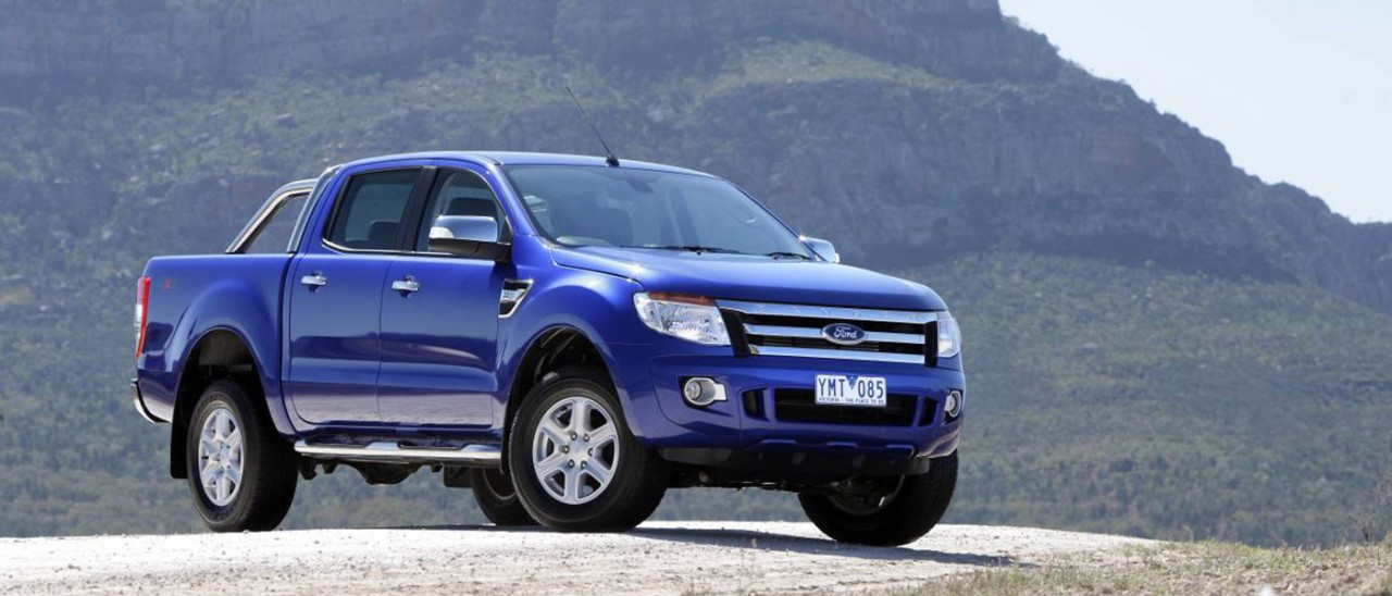 Blue Ford Ranger parked in front of mountain.