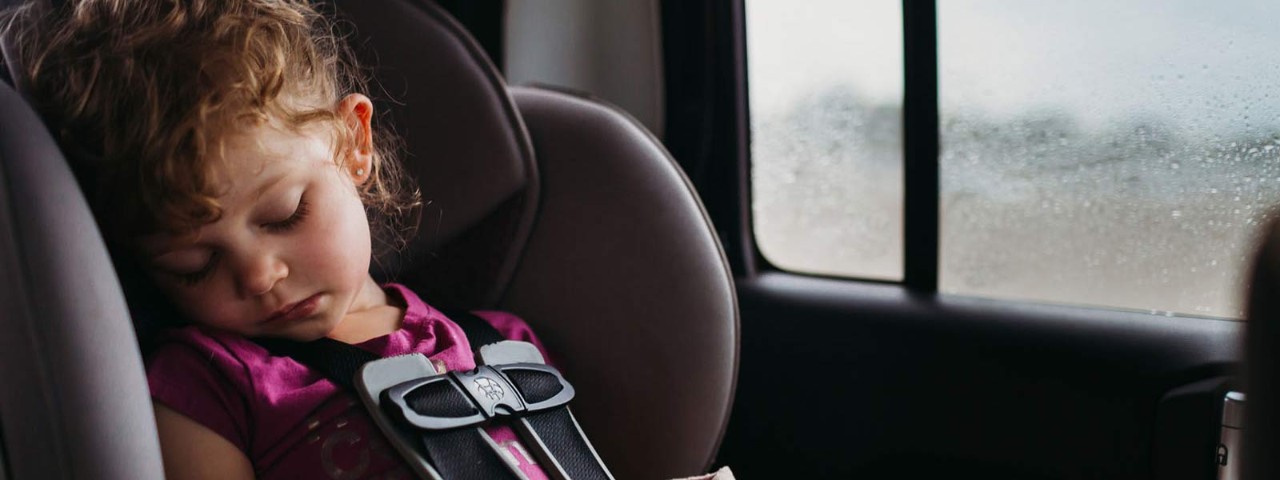 Young child asleep in car seat.