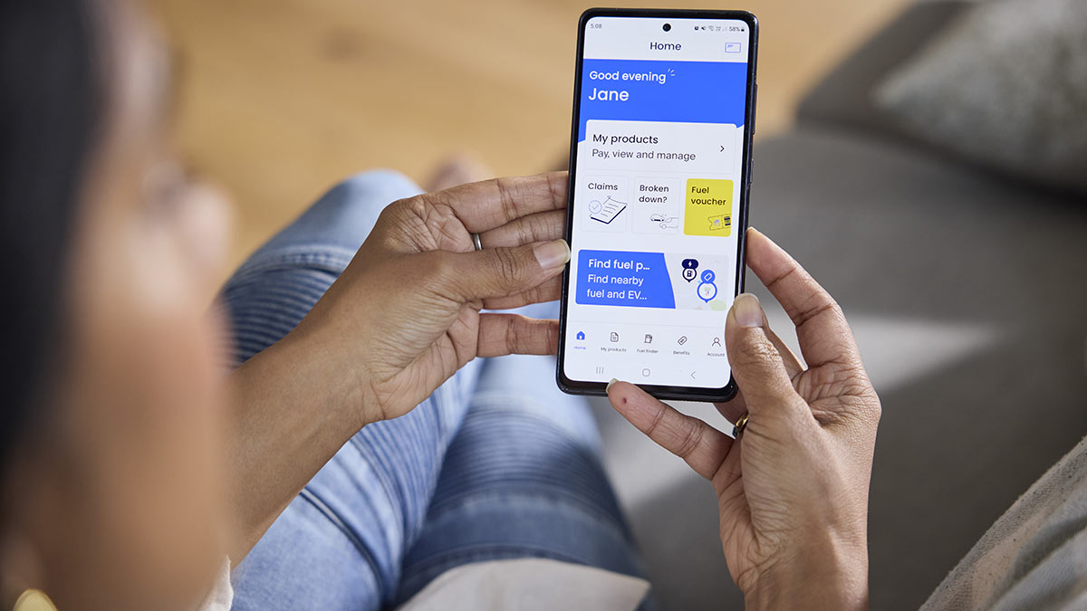 Woman looking at RACV App with icons for insurance claims, roadside emergency and fuel vouchers on phone.