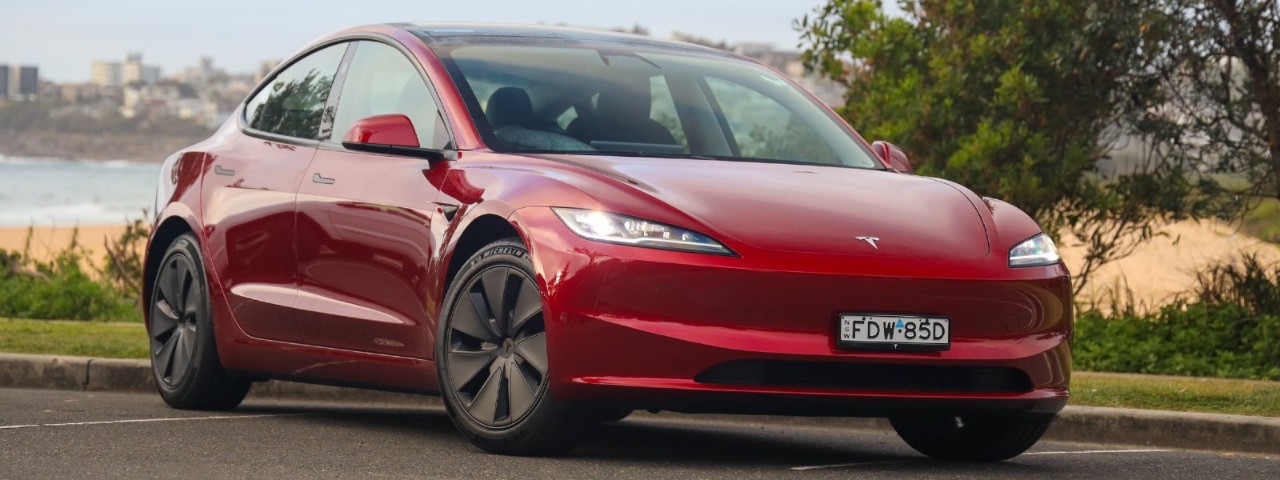 red Tesla Model 3 parked outdoors