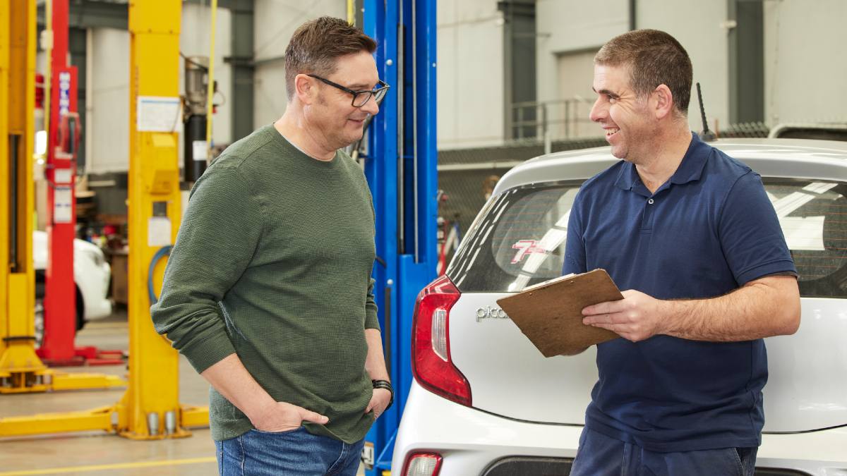 car mechanic talking to car owner