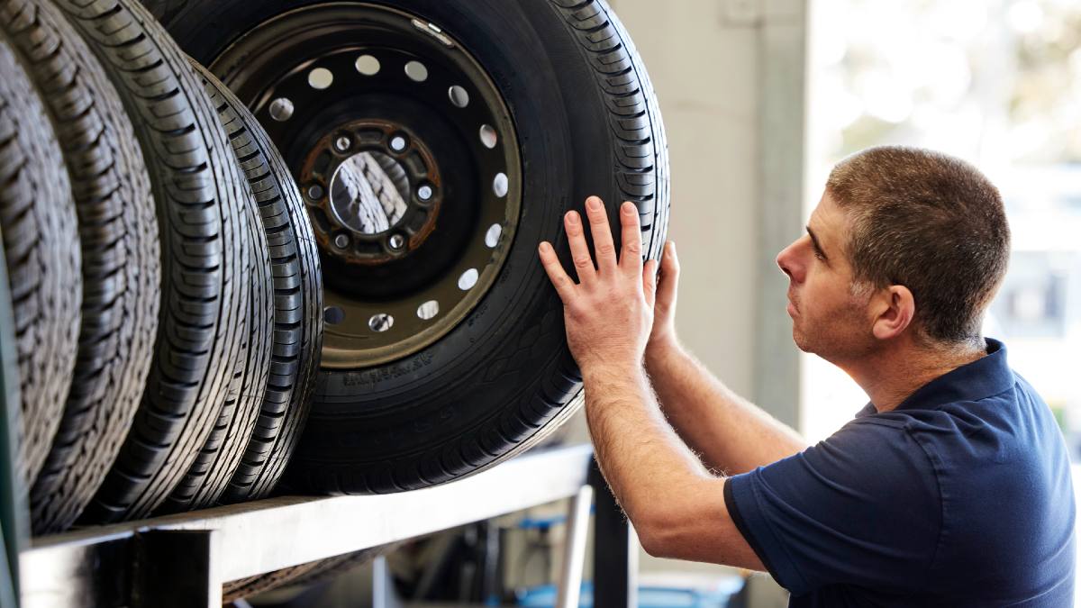 mechanic pulling out a tyre from storage