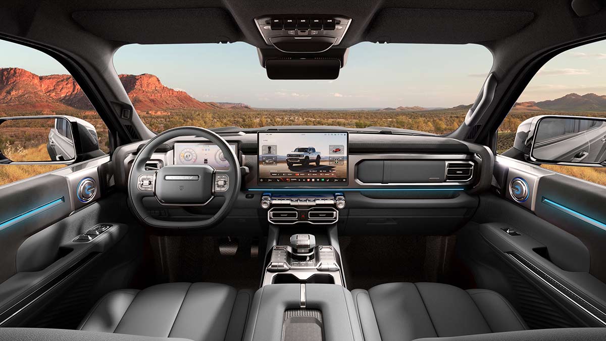 Front seat area of left-hand-drive Chery Stockman ute with large digital screens and horizontal design theme across interior.