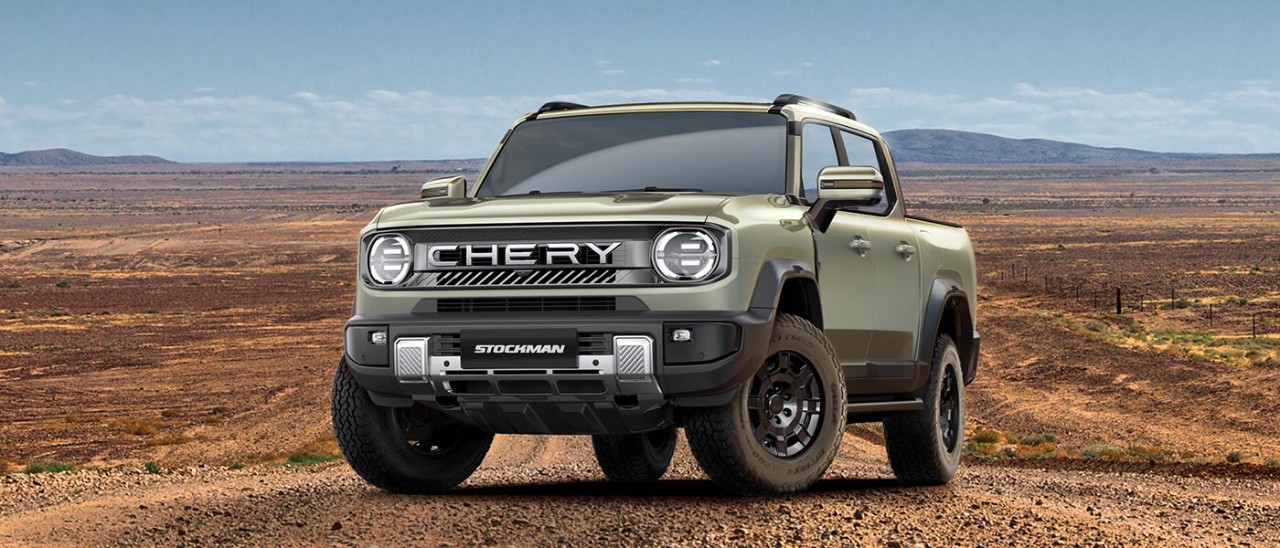 Light green Chery Stockman dual-cab ute in middle of red dirt road in Outback Australia landscape.