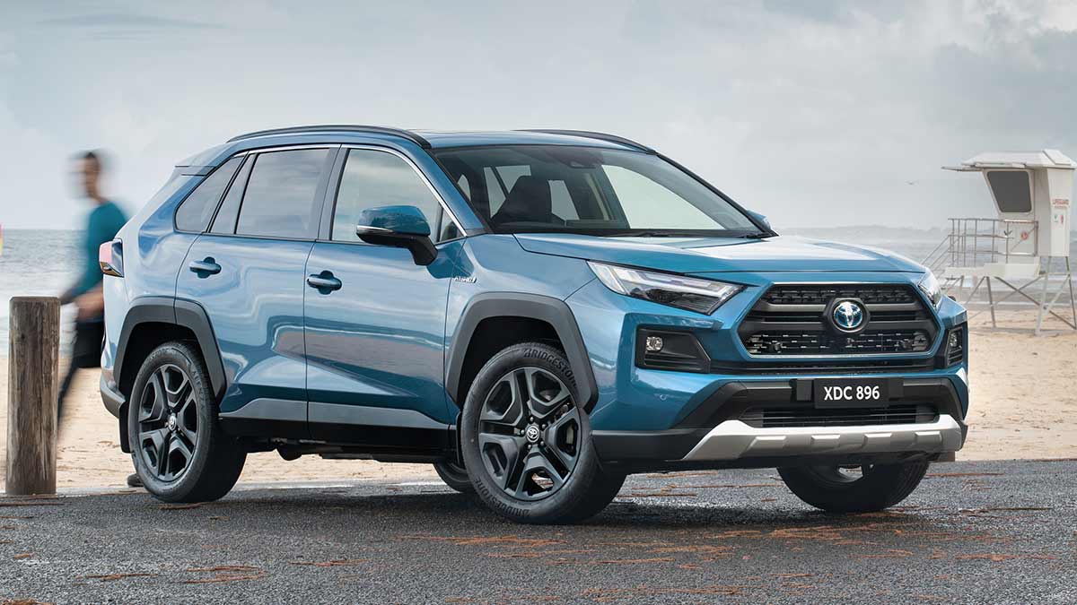 A blue Toyota RAV4 Edge hybrid parked by a beach.