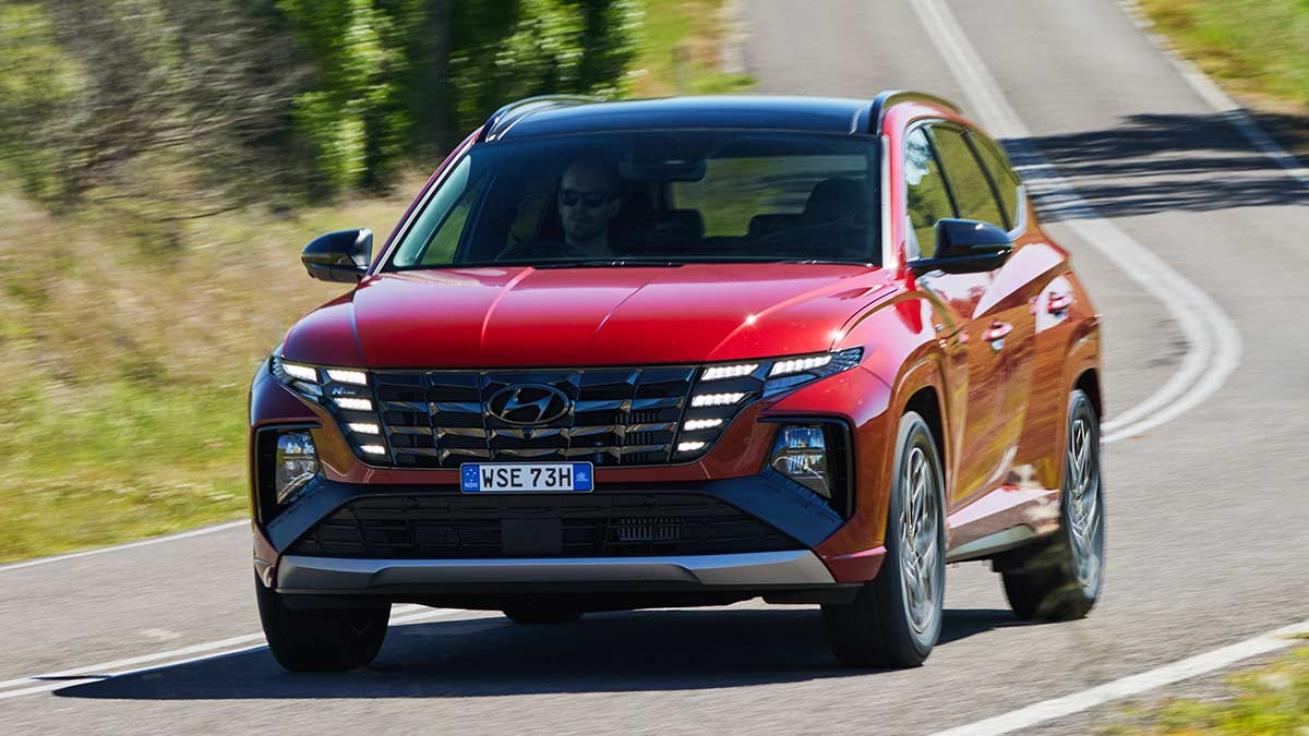 A red Hyundai Tucson Highlander on the road.