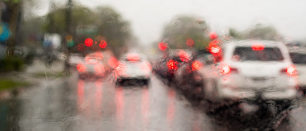 view through a car windscreen to a rainy road full of traffic