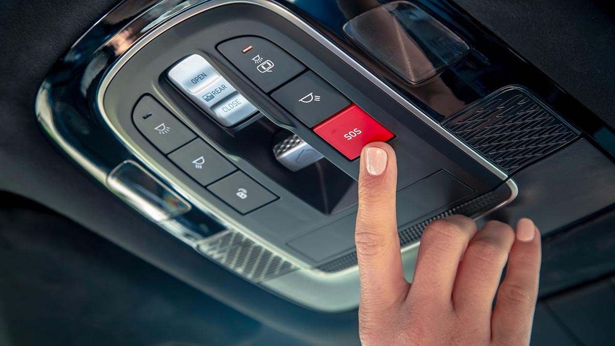 Finger on red SOS button in overhead console of Hyundai Palisade SUV