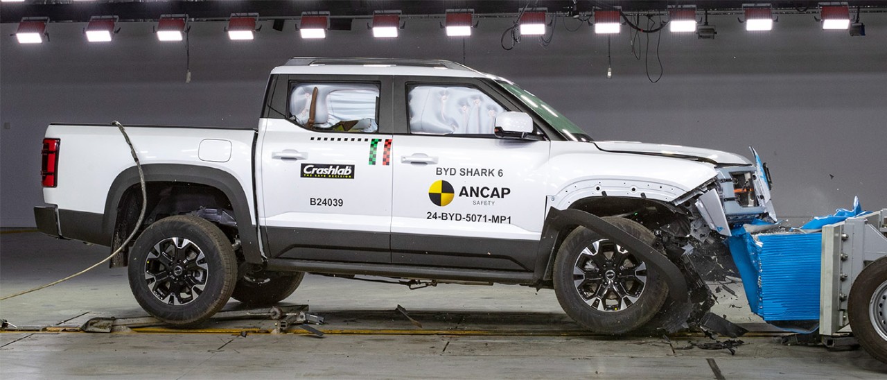 White BYD Shark 6 ute with damaged front end after crashing into deformable barrier for ANCAP testing.