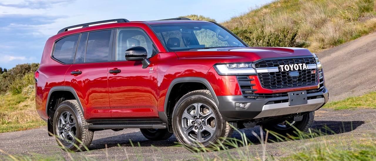 Red Toyota LandCruiser Hybrid at bottom of steep incline at proving ground in Altona.