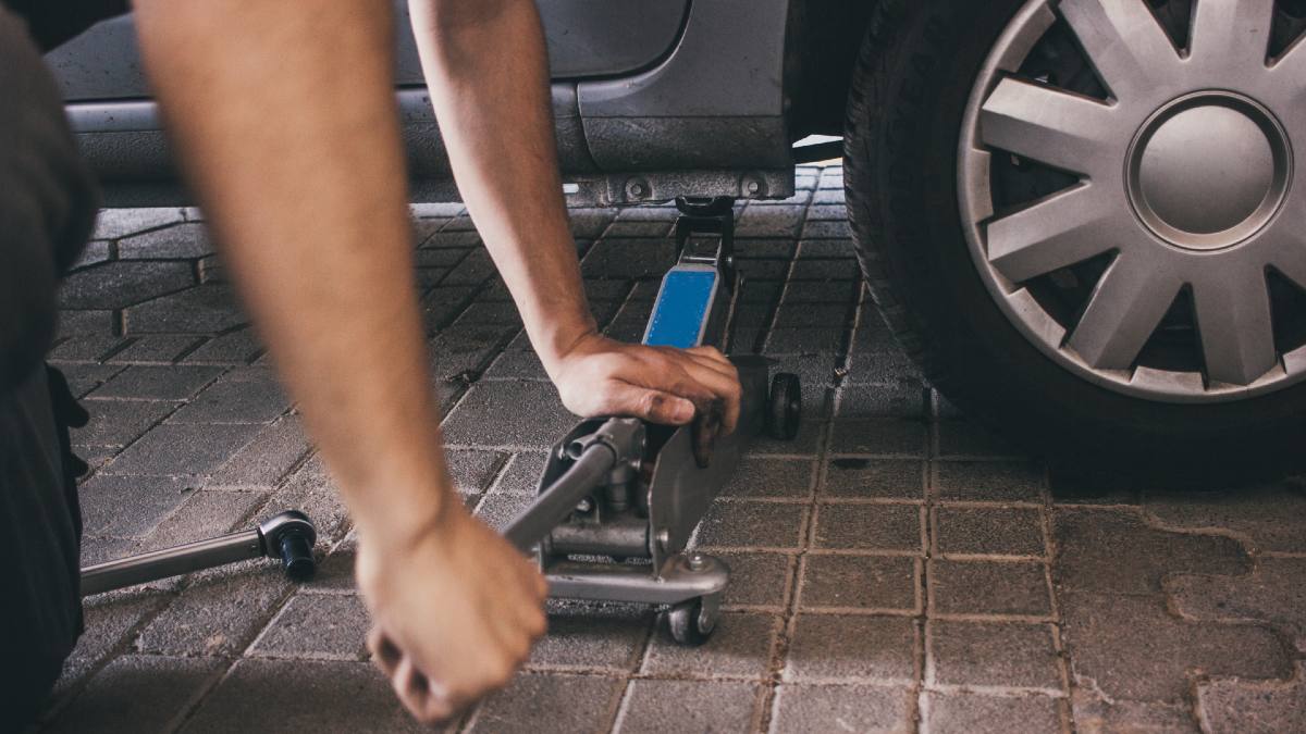 man jacking up his car