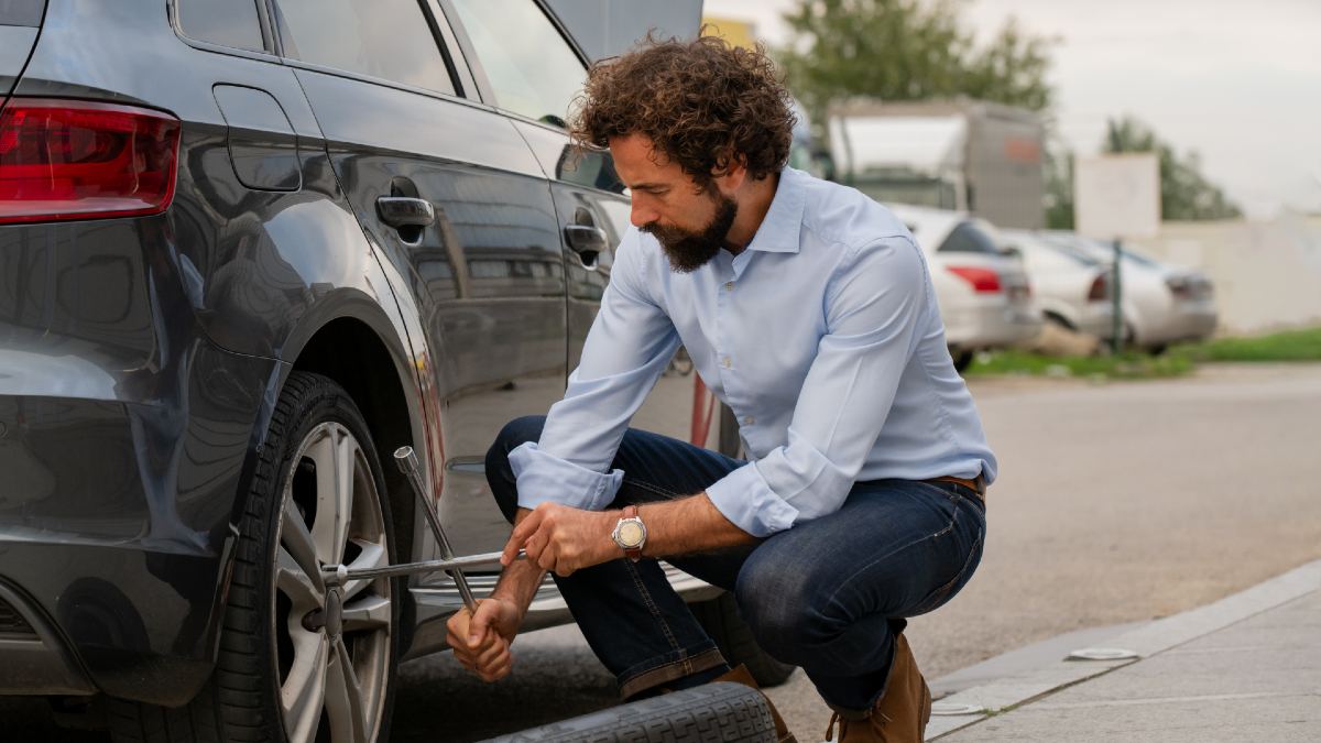 man using a lug wrench to secure car tyre nuts