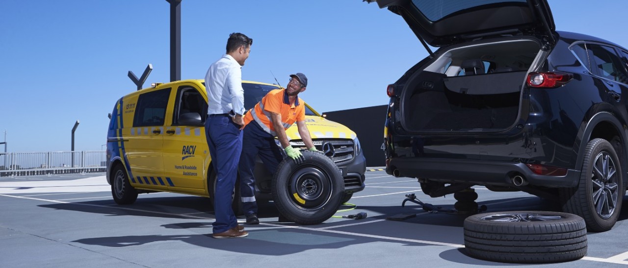 RACV ERA worker helps man change tyre on his SUV
