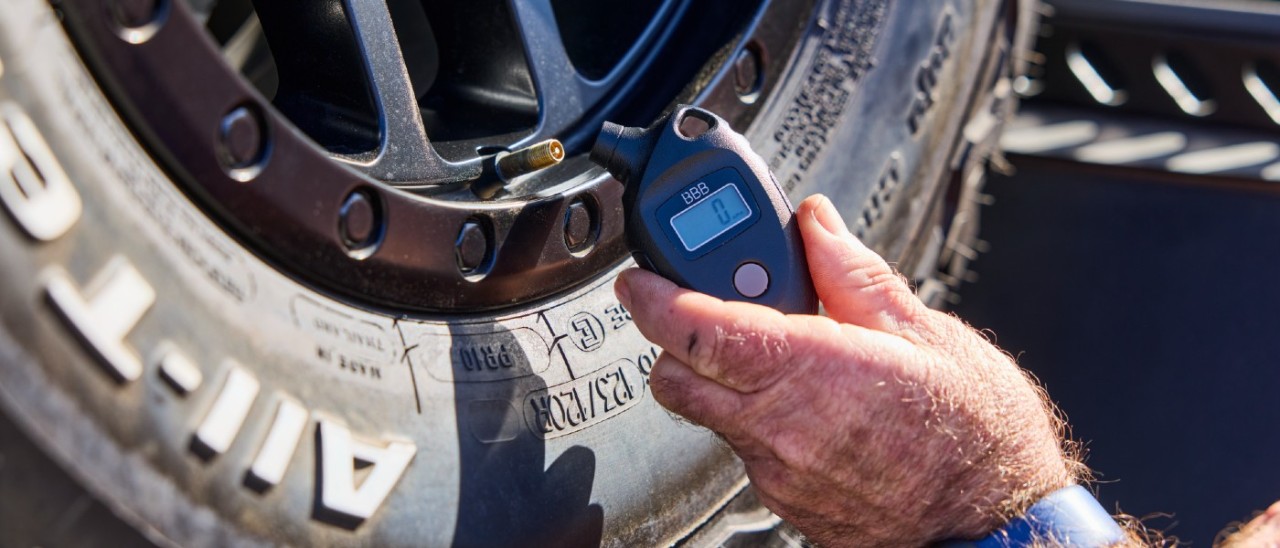 Tyre pressure A persons using a digital tyre gauge to check tyre pressure