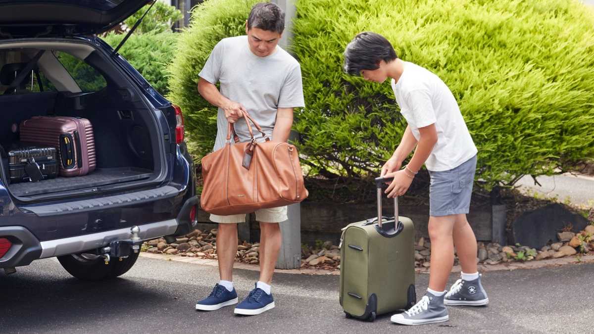 Father and child getting bikes out of car boot.